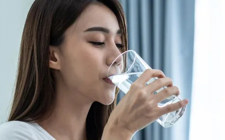 Perempuan dewasa meminum segelas air